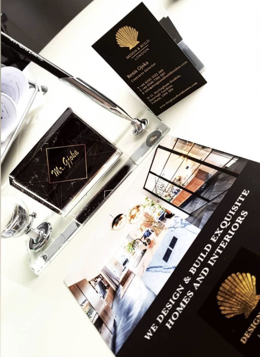 A collection of business marketing materials, including cards and brochures, showcasing interior design services.